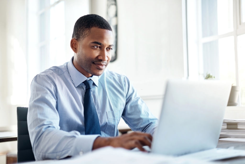 A handsome young businessman working on a laptop in an office